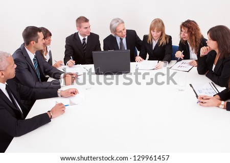 Businesspeople Sitting At Conference Table At The Meeting