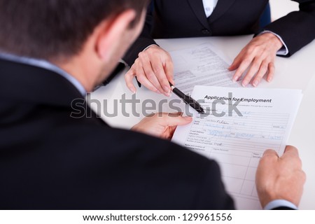 Businessman conducting an employment interview with an over the shoulder view of an application form