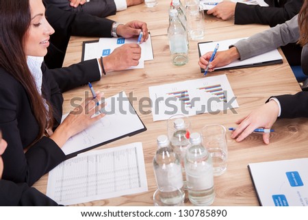Close-up of Businesspeople Sitting At Conference Table Communicating