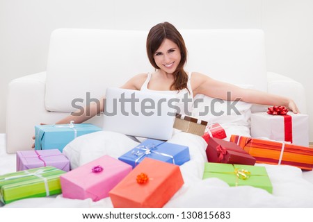 Young Woman Sitting On Bed And Shopping Online
