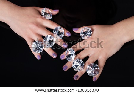 Close-up Of Woman\'s Hand And Diamonds Isolated On Black Background