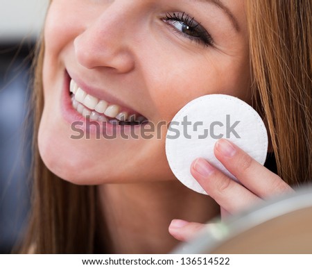 Portrait Of Young Woman Cleansing Her Face With Cotton
