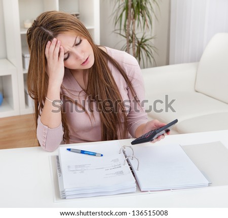 Young Worried Woman Calculating Bills At Home
