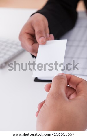 Close-up Of Business Hands Giving Visiting Card To Partner