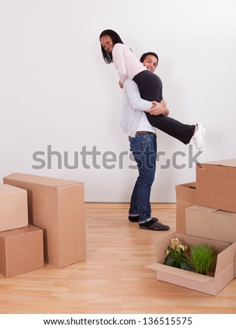 Portrait Of Man Carrying Woman On Shoulder In House