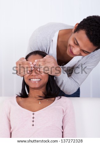 Portrait Of Young Man Covering Eyes Of Woman