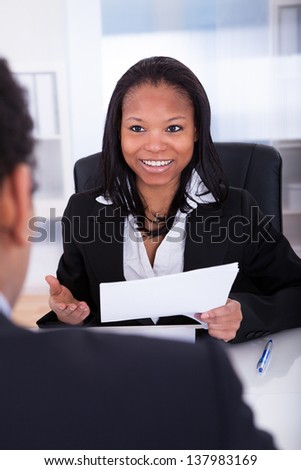 Businesswoman Discussing With His Co-Worker In Office