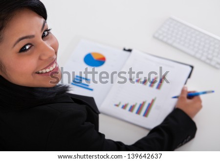 Close-up Of Businesswoman Studying Graph In Office
