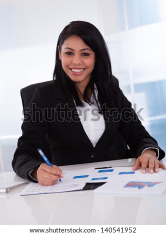 Happy Businesswoman In Office Working On Paper