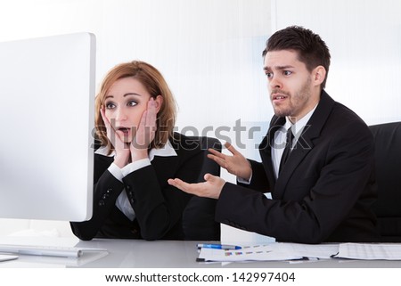 Two worried business partners looking at computer