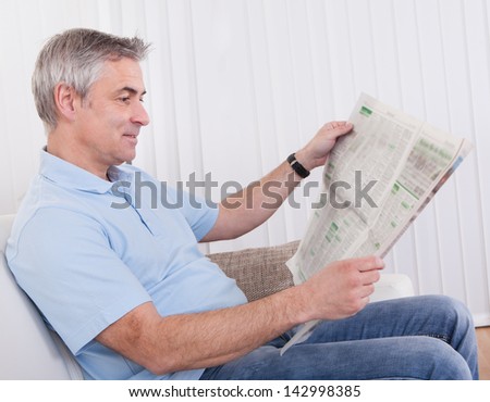 Portrait Of Happy Mature Man Reading Newspaper
