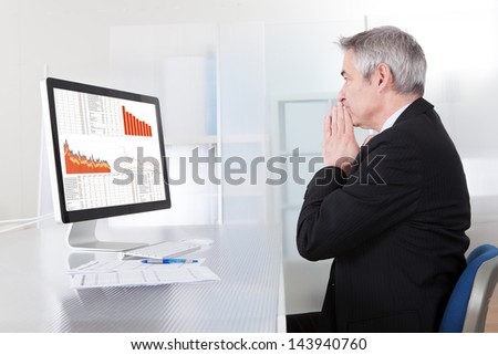 Portrait Of Confused Businessman With Computer In Office