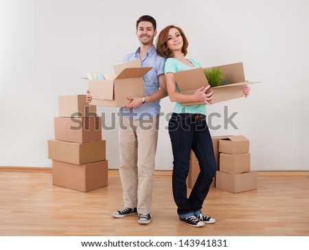 Young Happy Couple Holding Moving Into New House