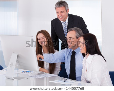 Portrait Of Happy Businesspeople Looking At Desktop