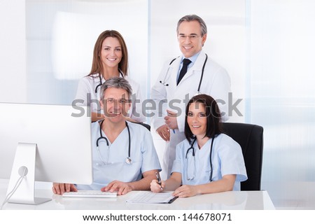 Female And Male Doctors Looking At Computer In Clinic