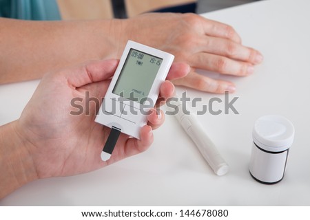 Close-up Of Hand Holding Sugar Level Checking Machine