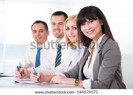 Business People Writing Meeting Notes In Office