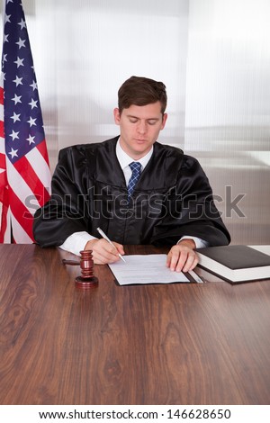 Male Judge With The Gavel And Book In Courtroom