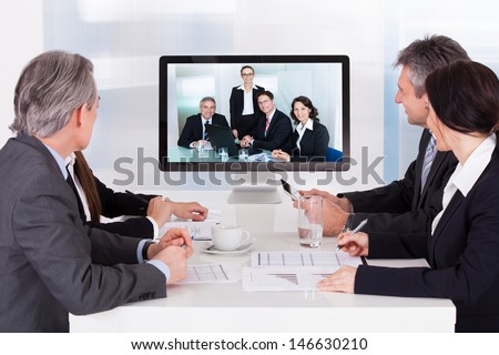 Group Of Businesspeople In Video Conference At Business Meeting Group Of Businesspeople In Video Conference At Business Meeting