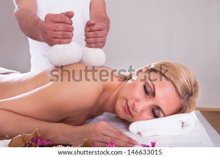 Beautiful Young Woman Getting Herbal Therapy At Spa Salon