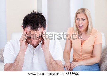 Portrait of woman shouting at man getting headache
