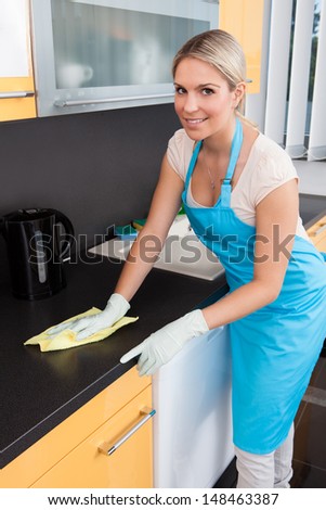 Portrait Of Happy Woman Cleaning Kitchen Worktop