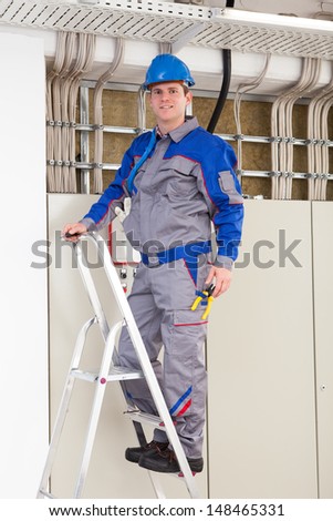 Young Worker Man With Hard Hat standing on ladder