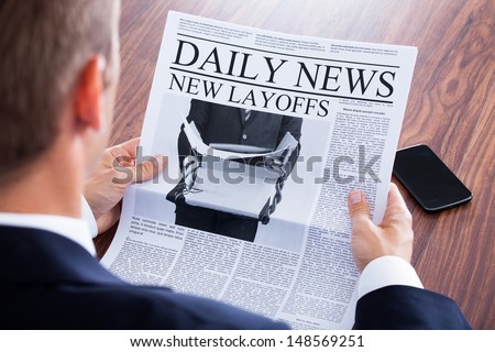 Close-Up Of Businessman Reading News On Newspaper