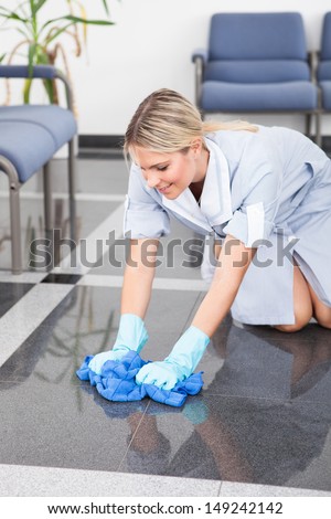 Young Happy Maid Cleaning The Floor With Cloth