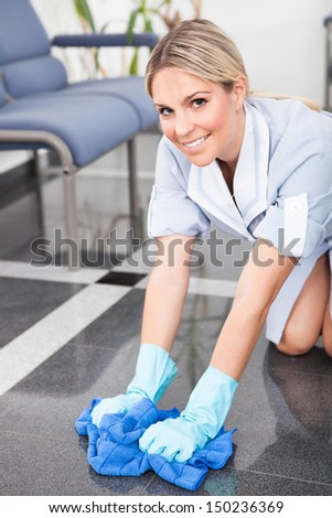 Young Happy Maid Cleaning The Floor With Cloth