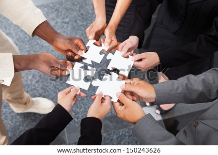 Close-Up Photo Of Businesspeople Holding Jigsaw Puzzle