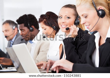 Happy Co-workers Wearing Headsets Working In Call Center