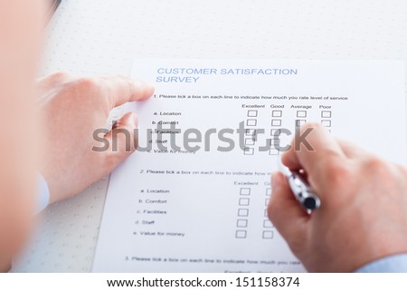Close-up Of Hand Holding Pen Over Blank Check Box In Application Form