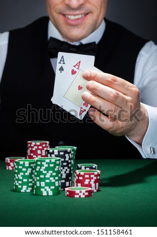 Close-up of a croupier holding aces of spade and heart