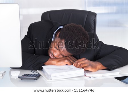 Portrait Of Stressed Businessman Sleeping In Office