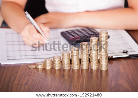 Close-up Of Woman At Work In Front Of Coin Graph