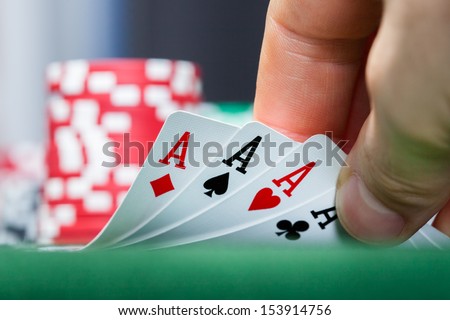Close-Up Of A Poker Player Holding Playing Cards