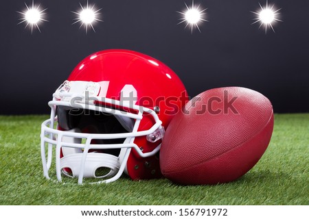 Red Sports Helmet Lying On Green Grass Field