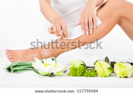 Beautician Waxing A Woman\'S Leg In Spa