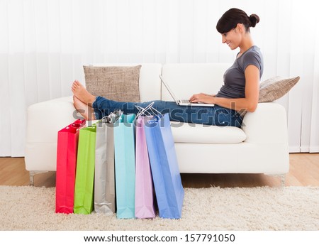 Young Beautiful Woman Sitting On Couch Shopping Online