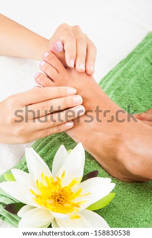 Close-up Of Woman Feet Receiving Foot Massage In Spa