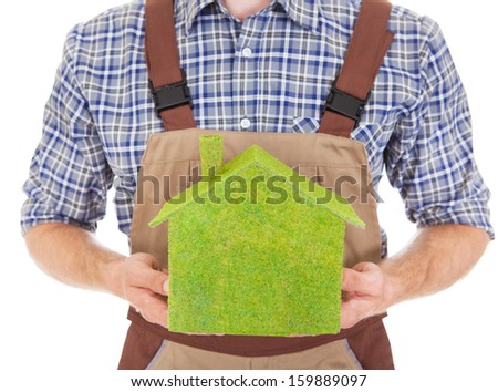 Portrait Of A Construction Worker Holding Green Ecological House