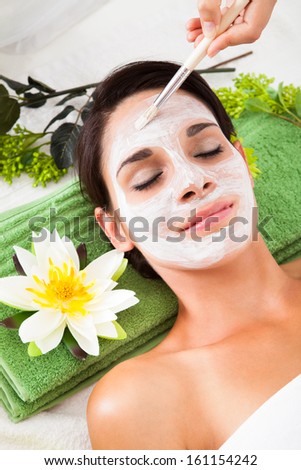Cosmetician Applying Facial Beauty Mask For Young Woman At Spa Salon