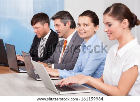 Happy Businesspeople In A Row Working Together At Office