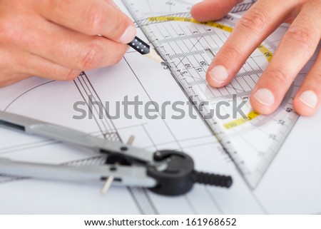 Close-up Of Person\'s Hand Drawing Plan On Blue Print