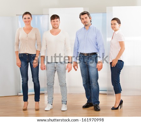 Happy Group Of People Standing Together On Hardwood Floor