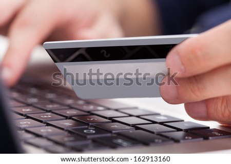 Person Holding Credit Card And Shopping Online Using Laptop