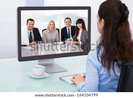 Businesswoman Sitting At A Desk Watching An Online Presentation On The Computer