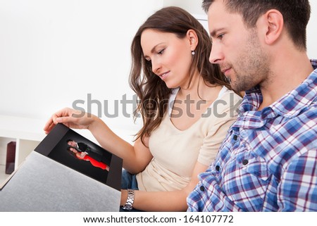 Man And Woman Looking At Couples Picture In Album