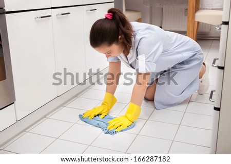 Portrait Of Young Maid Wearing Gloves Cleaning Floor